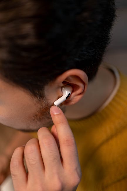 Close-up of hands adjusting wireless earbud ear tips for a proper seal