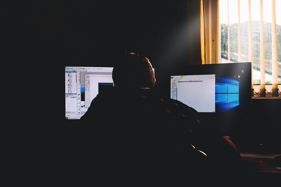 Person working at a desk with multiple monitors connected to a dock
