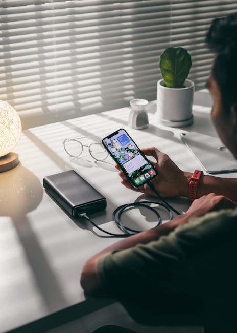 Person plugging phone into a trusted USB charger at a clean desk