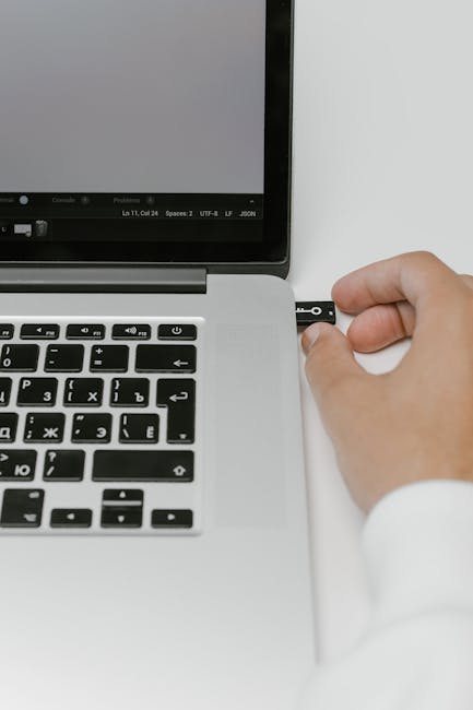 Person examining laptop ports and cables before connecting an external monitor.