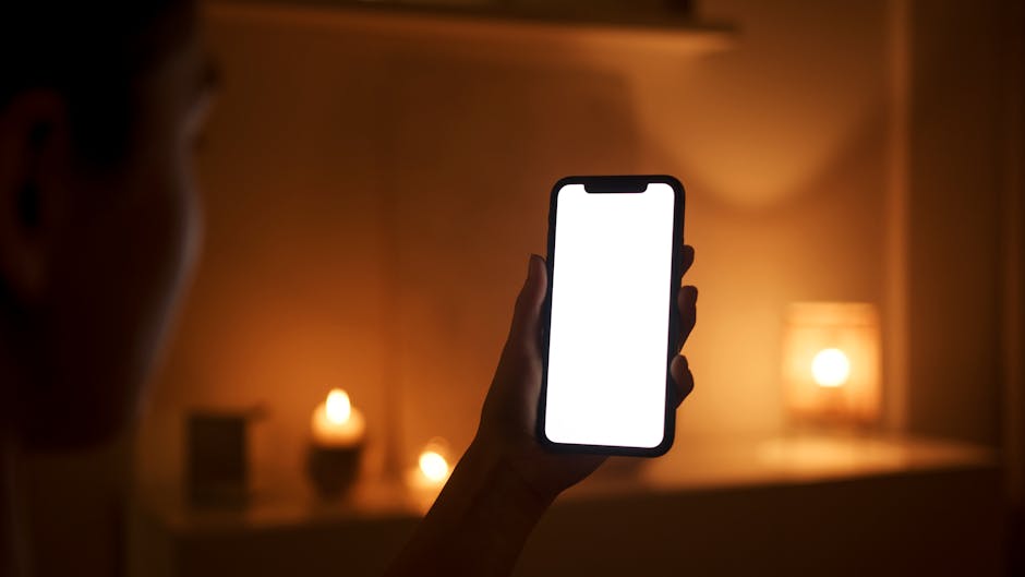 Person steadying a smartphone at night while zooming toward distant lights