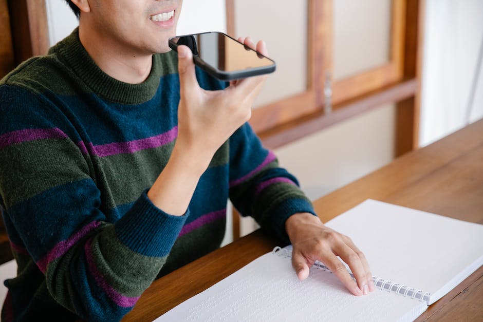 Person recording a voice memo on a phone while testing wireless earbuds mic quality