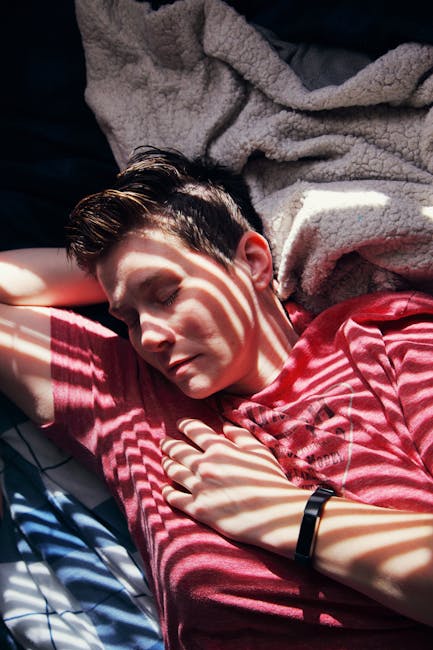 Person wearing a fitness tracker or smartwatch in bed during sleep