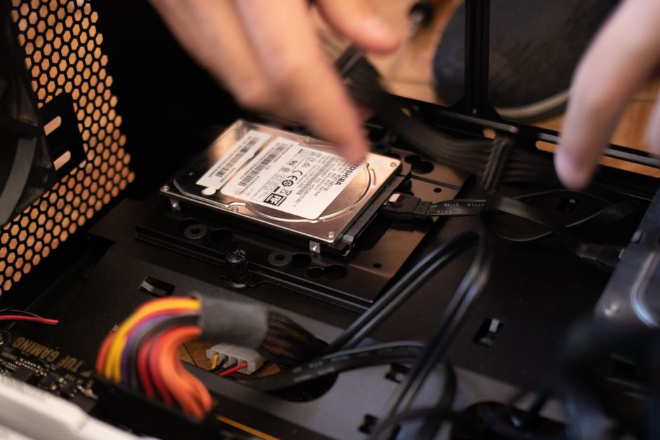 Computer technician installing an SSD drive into a desktop system
