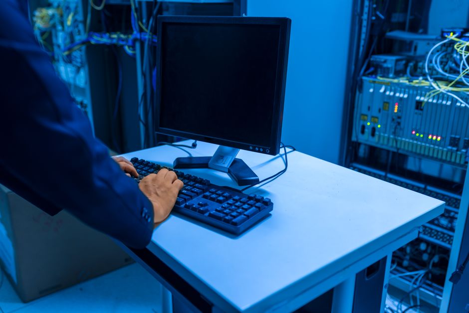 IT professional reviewing device logs and network monitoring dashboards after a firmware update