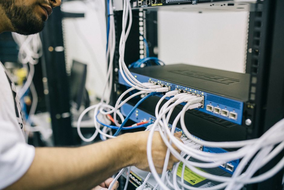 Team member disconnecting an infected laptop from the network by unplugging Ethernet